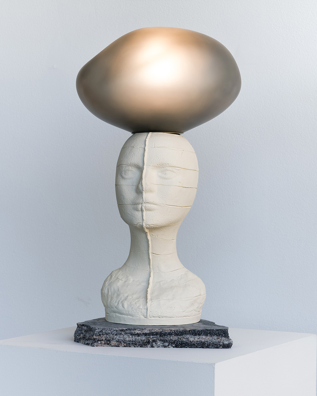 "What We Carry" lamp sculpture with hand-blown glass orb – merging art and product design.