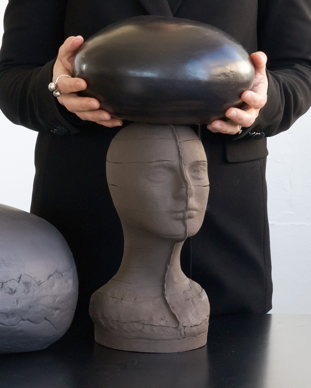 Exploring various clay bodies: black stoneware head with black iron oxide terra sigillata orb.